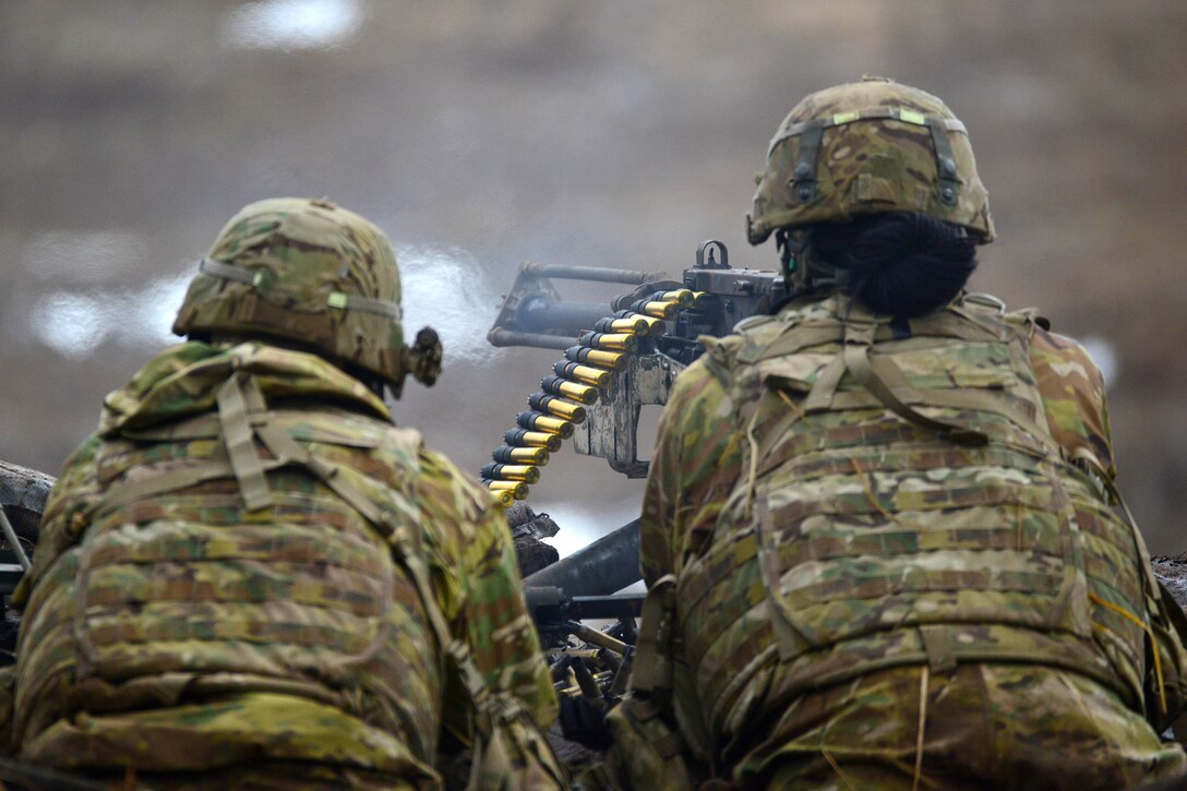 Soldiers fire a M2 machine gun.