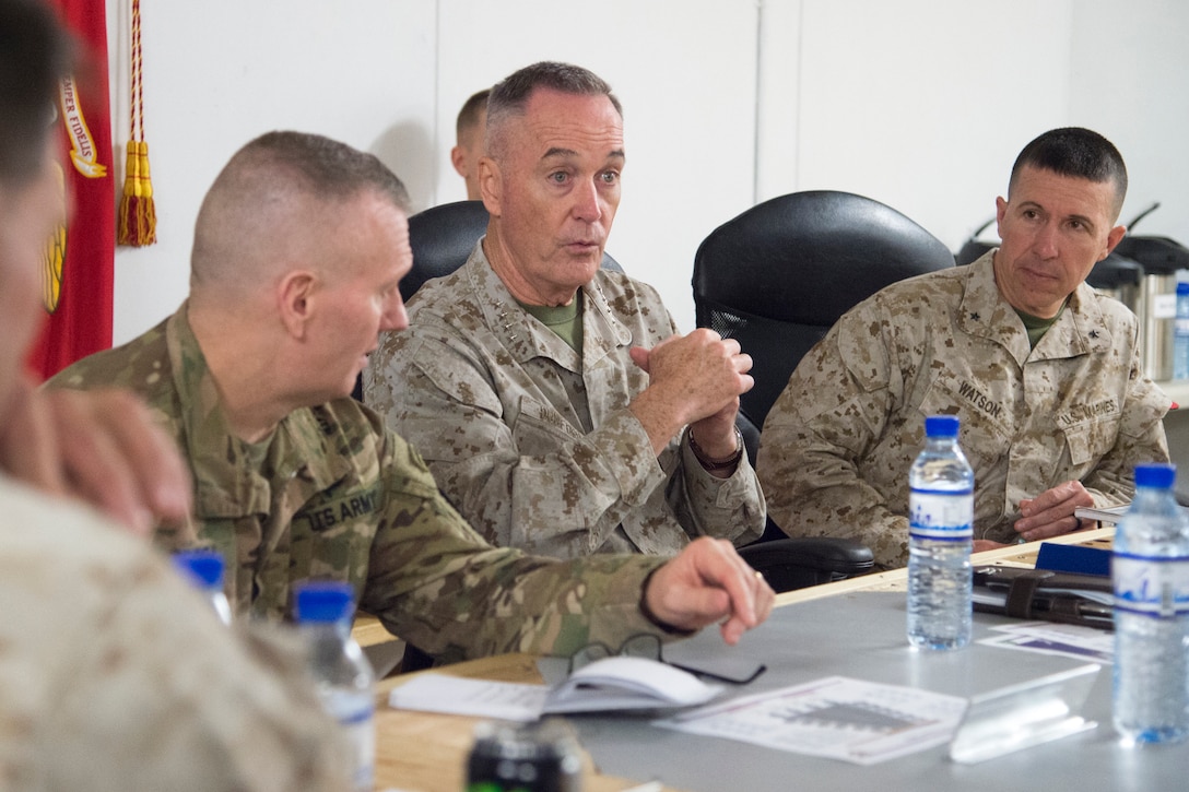 Marine Corps Gen. Joe Dunford speaks at a table as other service members listen.