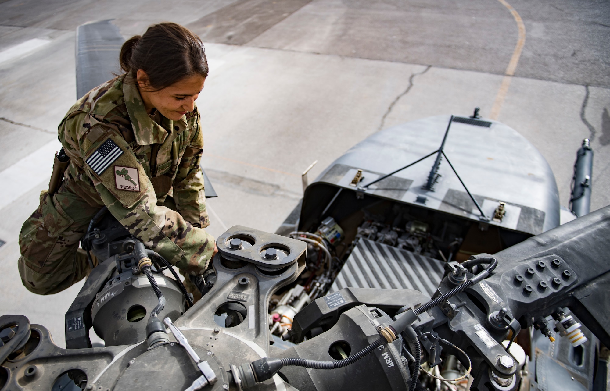 U.S. Air Force Airman 1st Class Ashley Amezola, HH-60G Pave Hawk crew chief assigned to the 451st Expeditionary Aircraft Maintenance Squadron, conducts maintenance on one of the helicopters before a training mission, March 13, 2018 at Kandahar Airfield, Afghanistan.