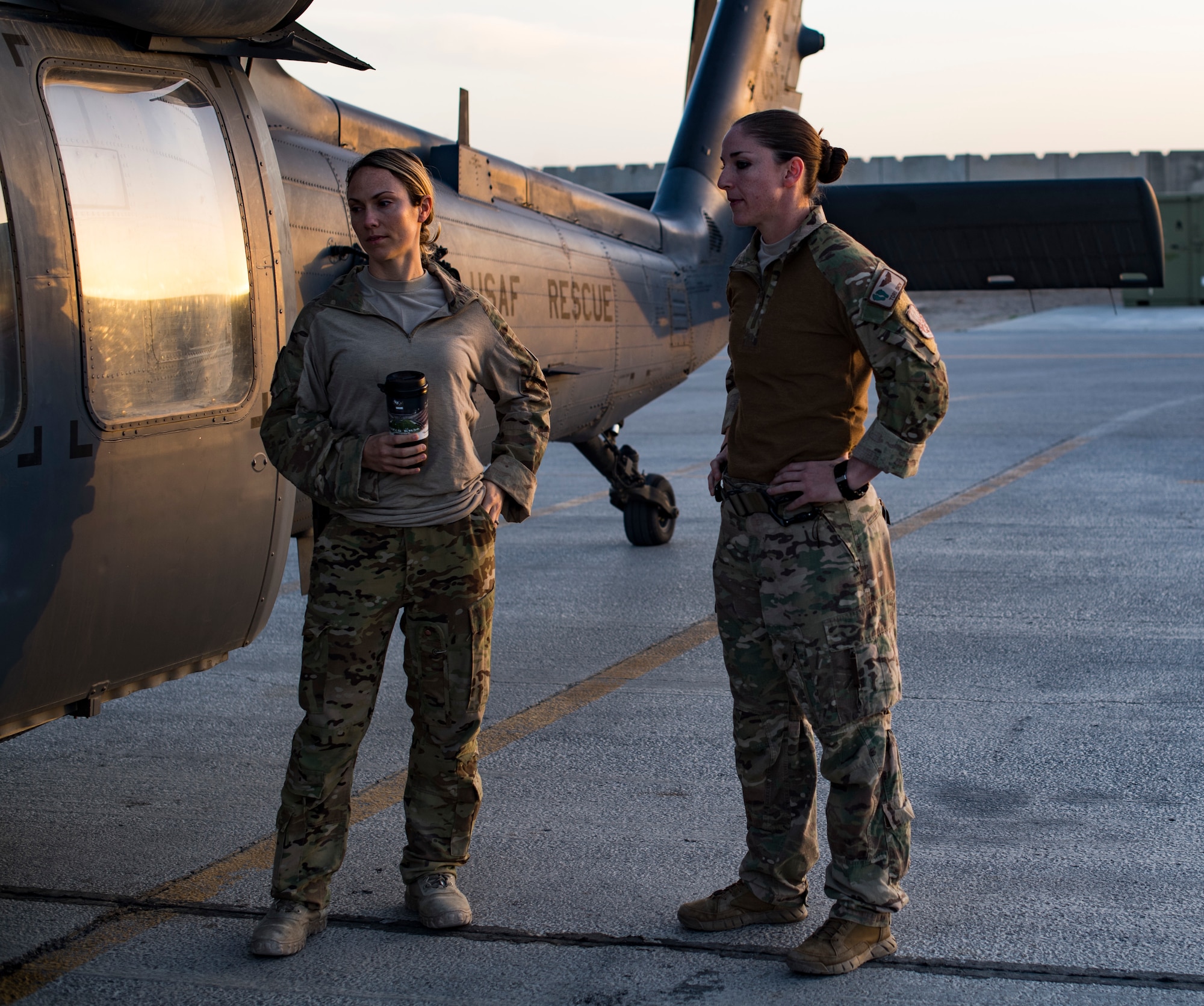 U.S. Air Force Maj. Margaret McCord, commander of the 33rd Expeditionary Rescue Squadron, and Capt. Victoria Snow, HH-60G Pave Hawk pilot assigned to the 33rd ERQS, discuss tactics in front of the aircraft after training mission with a Guardian Angel team assigned to the 308th ERQS, Kandahar Airfield, Afghanistan, March 13, 2018.