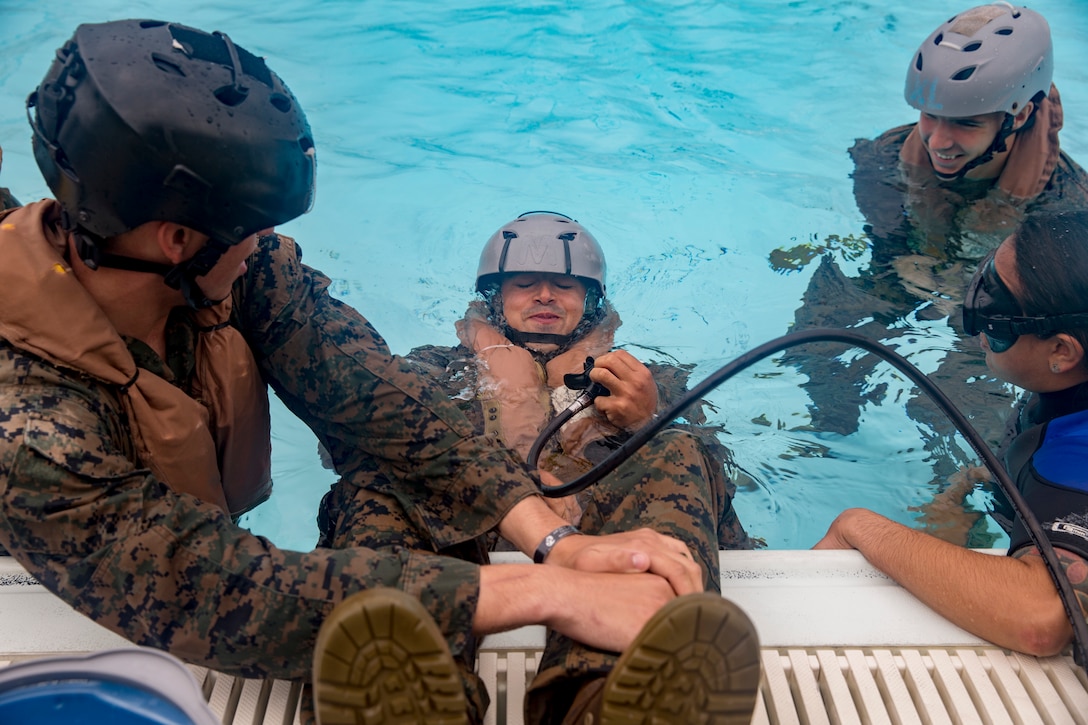 U.S. Marine Lance Cpl. Robert Stotts holds his breath to practice using the air tank during underwater egress training (UET) aboard Camp Hansen, Okinawa, Japan, Mar. 21, 2018. UET prepares Marines to escape a helicopter in the event of a mishap and lands in the water.  Stotts, a Colorado Springs, Colorado native, is a mortar man with 3rd Battalion, 3rd Marine Regiment, 3rd Marine Division. The Hawaii-based unit is currently forward-deployed to Okinawa, Japan, as part of the unit deployment program. (U.S. Marine Corps photo by Sgt. Ricky Gomez)
