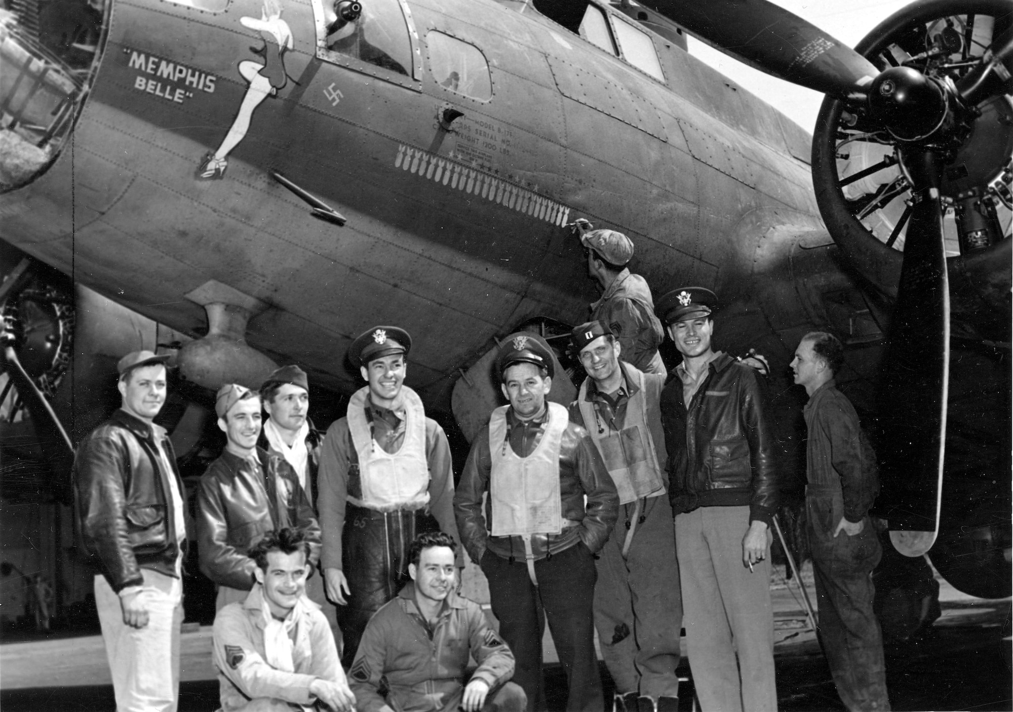 Maj Wyler (fourth from right) with some of the Memphis Belle crew.  Wyler flew two of his five combat missions on the Memphis Belle, including the crew’s 25th mission.  This photograph was taken after that mission—crew chief MSgt Joseph Giambrone is painting on the 25th bomb.