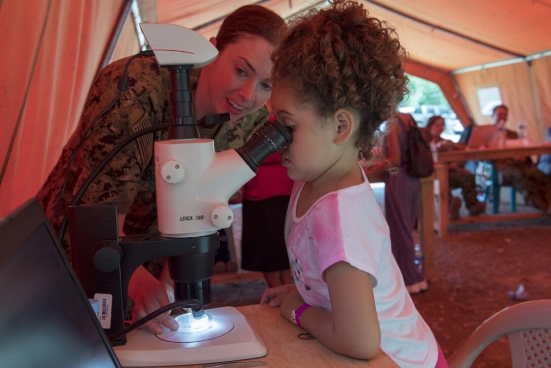 A child looks in a microscope.