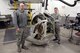Master Sgt. Garth Shannon and Staff Sgt. Robert Wheeler, 388th Maintenance Squadron, pose beside a B-24 gun turret at Hill Air Force Base, Utah, Feb. 28, 2018. Maintenance shops from the squadron are restoring the turret for the Hill Aerospace Museum. (U.S. Air Force photo by Todd Cromar)