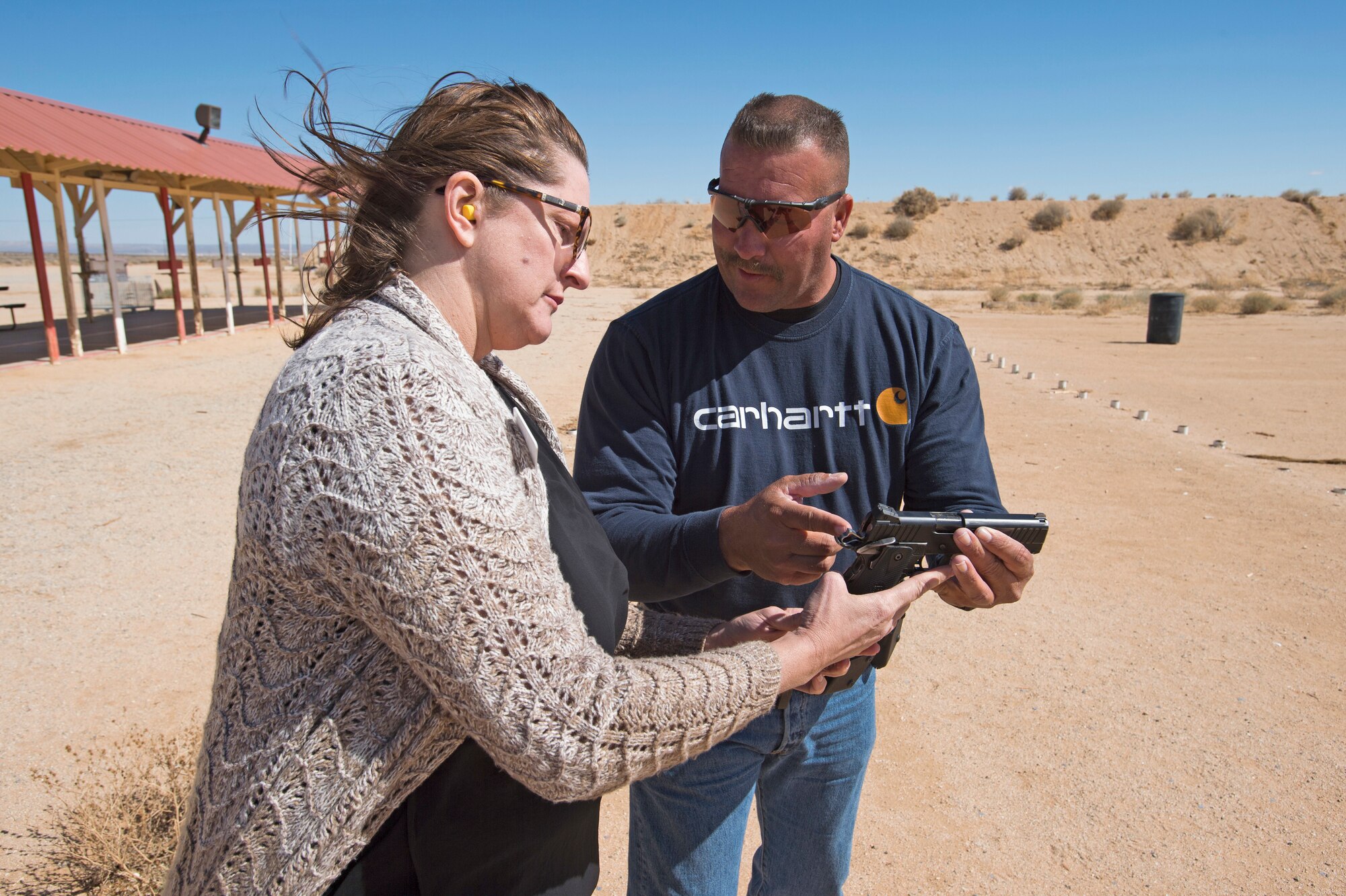 Cynthia Poole, 412th Test Management Group honorary commander, gets a lesson on firing a hand gun from Francis “Len” Paris, 412th Civil Engineer Group and Rod and Gun Club member March 16. (U.S. Air Force photo by Joseph Pol Sebastian Gocong)
