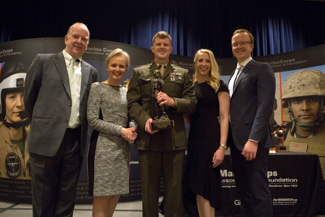 Capt. Joshua B. Kelly, a logistician with 25th Marine Regiment, 4th Marine Division, Marine Forces Reserve, poses with his family after receiving the First Lieutenant Travis Manion Marine Corps Officer Logistician award at the Marine Corps Association and Foundation's 14th annual Ground Logistics Awards Dinner at the Crystal Gateway Marriott, Arlington, Virginia, March 22, 2018. Kelly was given the award in part for his efforts of providing new and advance means of logistical support within his unit during the 2017 fiscal year. (U.S. Marine Corps photo by Cpl. Dallas Johnson)