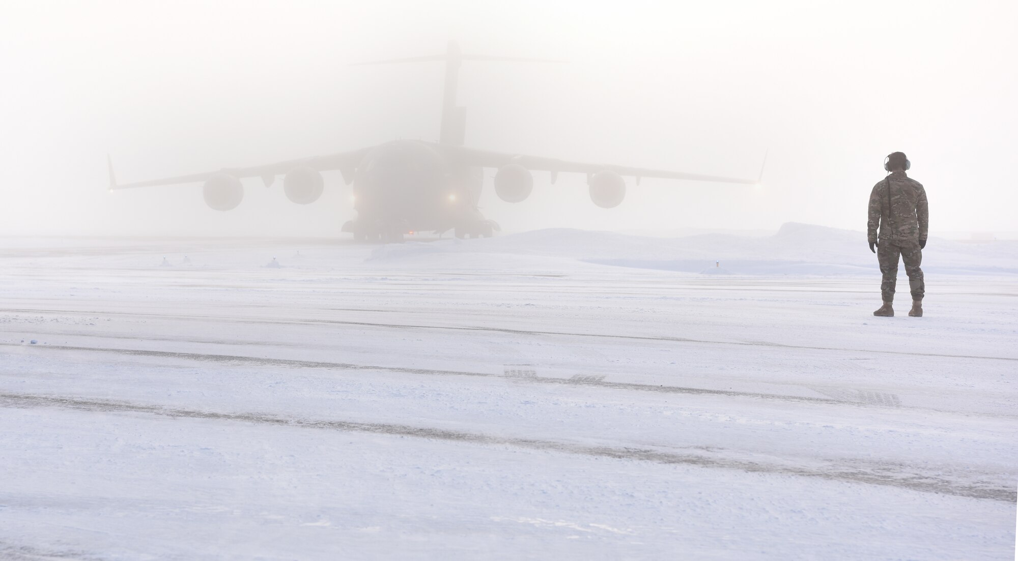 1st. Lt. Alex Hoffman, 7th Airlift Squadron pilot, watches a C-17 Globemaster III taxi to its spot during Exercise Arctic Pegasus at Deadhorse, Alaska, March 13, 2018. Airmen assigned to the 62nd Airlift Wing out of McChord Field, Wash., participated in the exercise to deliver Soldiers and four Strykers to Deadhorse. (U.S. Air Force photo by Senior Airman Tryphena Mayhugh)