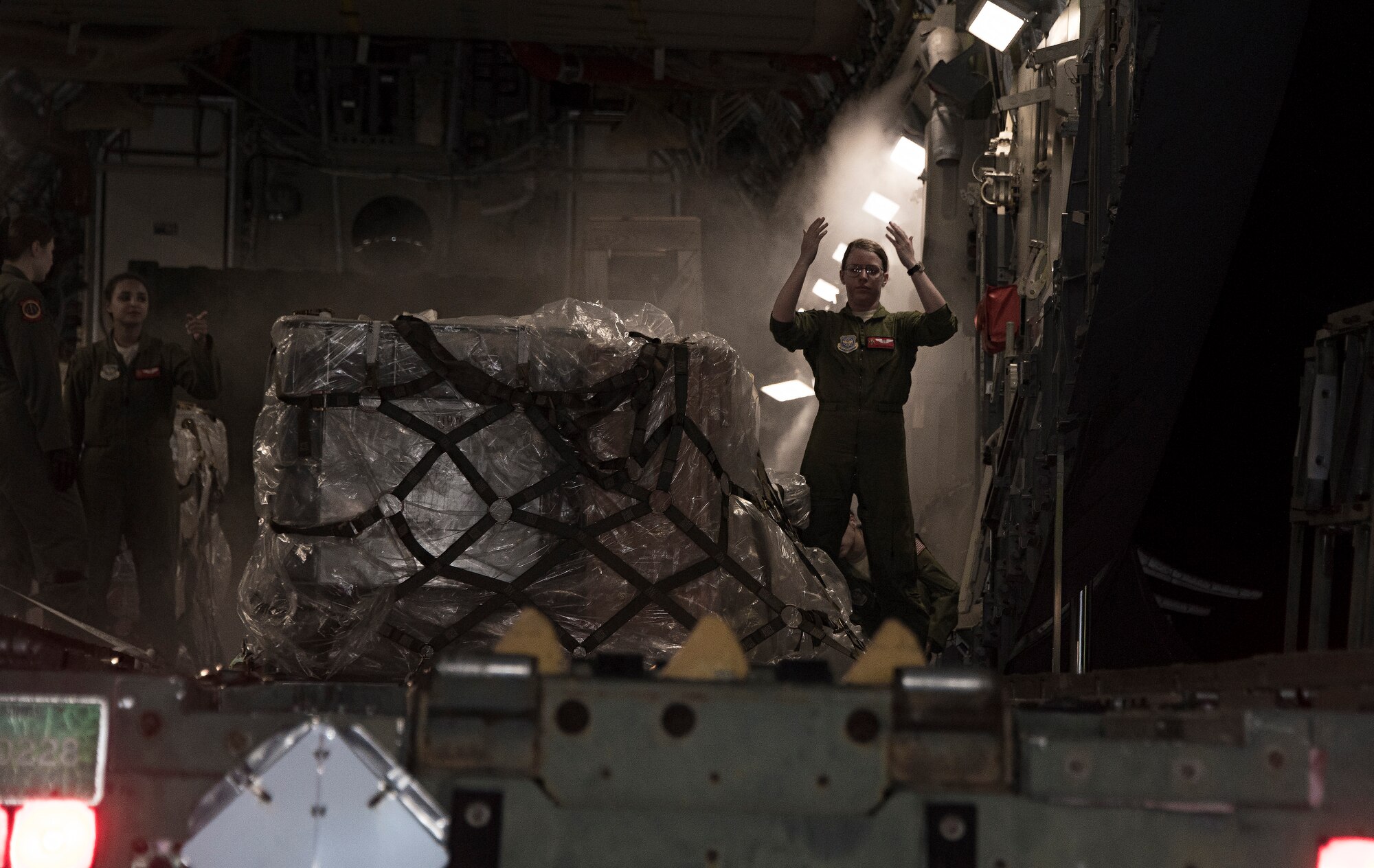 Airman 1st Class Alexia Lewis, a loadmaster assigned to the 21st Airlift Squadron marshals a tunner loader into position, March 18, 2018, at Andersen Air Force Base, Guam, during a Women's Heritage Flight. Lewis was part of an all-female C-17 Globemaster III crew that honored Women's History Month and highlighted AMC's ability to conduct rapid global mobility in today’s Air Force by delivering equipment and military personnel to the Pacific Command area of responsibility. (U.S. Air Force photo by Heide Couch)