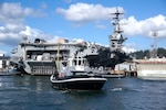 Harbor tug Defiant (YT 804) and crew wait to assist while USS Nimitz (CVN 68) is being positioned for docking at Puget Sound Naval Shipyard & Intermediate Maintenance Facility in Bremerton, Washington March 1, 2018.