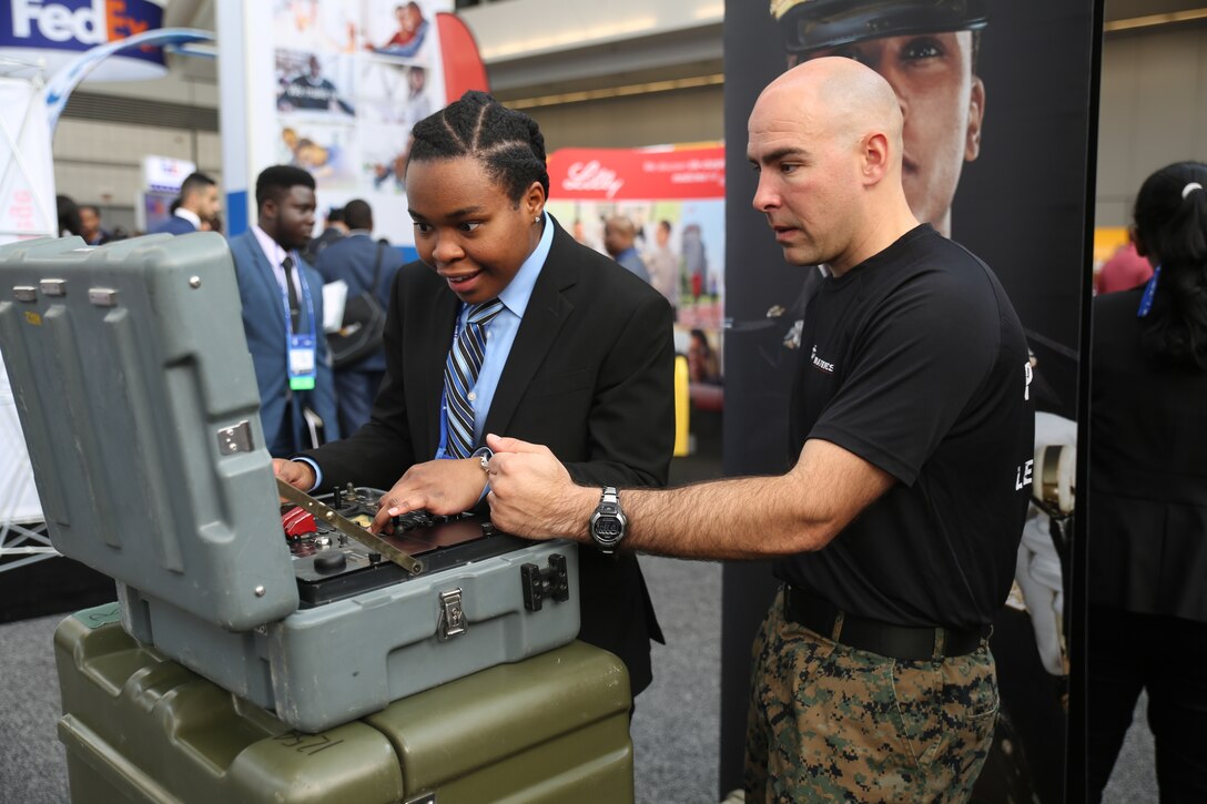 Jeanette Greene, a senior civil engineer major at the University of Missouri-Columbia, works with an Explosive Ordnance Disposal (EOD) Marine to maneuver the MK-2 Mod 1 Talon robot during the National Society of Black Engineers (NSBE) 44th Annual National Convention at the David L. Lawrence Convention Center in Pittsburgh, March 22. EOD Marines use the MK-2 Mod 1 Talon robot to assess situations and identify possible explosives before sweeping the area with an improvised explosive device (IED) detector. The MK-2 robot allows Marines to get visuals on a threat without endangering themselves. (U.S. Marine Corps photo by Sgt. Courtney G. White)