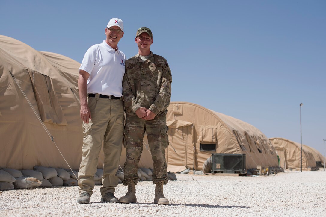 Gino Rakas (left), Army and Air Force Exchange Service services business program specialist for Europe, Southwest Asia and Africa; and Airman 1st Class Alexander Rakas, 332nd Expeditionary Maintenance Squadron munition system specialist, pose for a photo at an undisclosed location in Southwest Asia March 21, 2018.