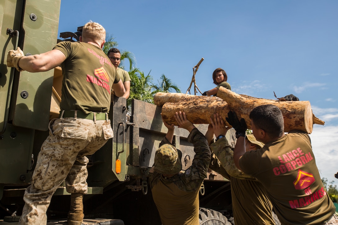 U.S. Marines and Australian Defence Force service members load a tree trunk into a truck at Darwin, NT, Australia March 20, 2018. Approximately Marines and 300 Australian Defence Force service members helped clear road and pathways around the Darwin area. The relief efforts arose after Tropical Cyclone Marcus, category 2, swept through coastal parts of the Northern Territory. (U.S. Marine Corps photo by Lance Cpl. Mason Roy)