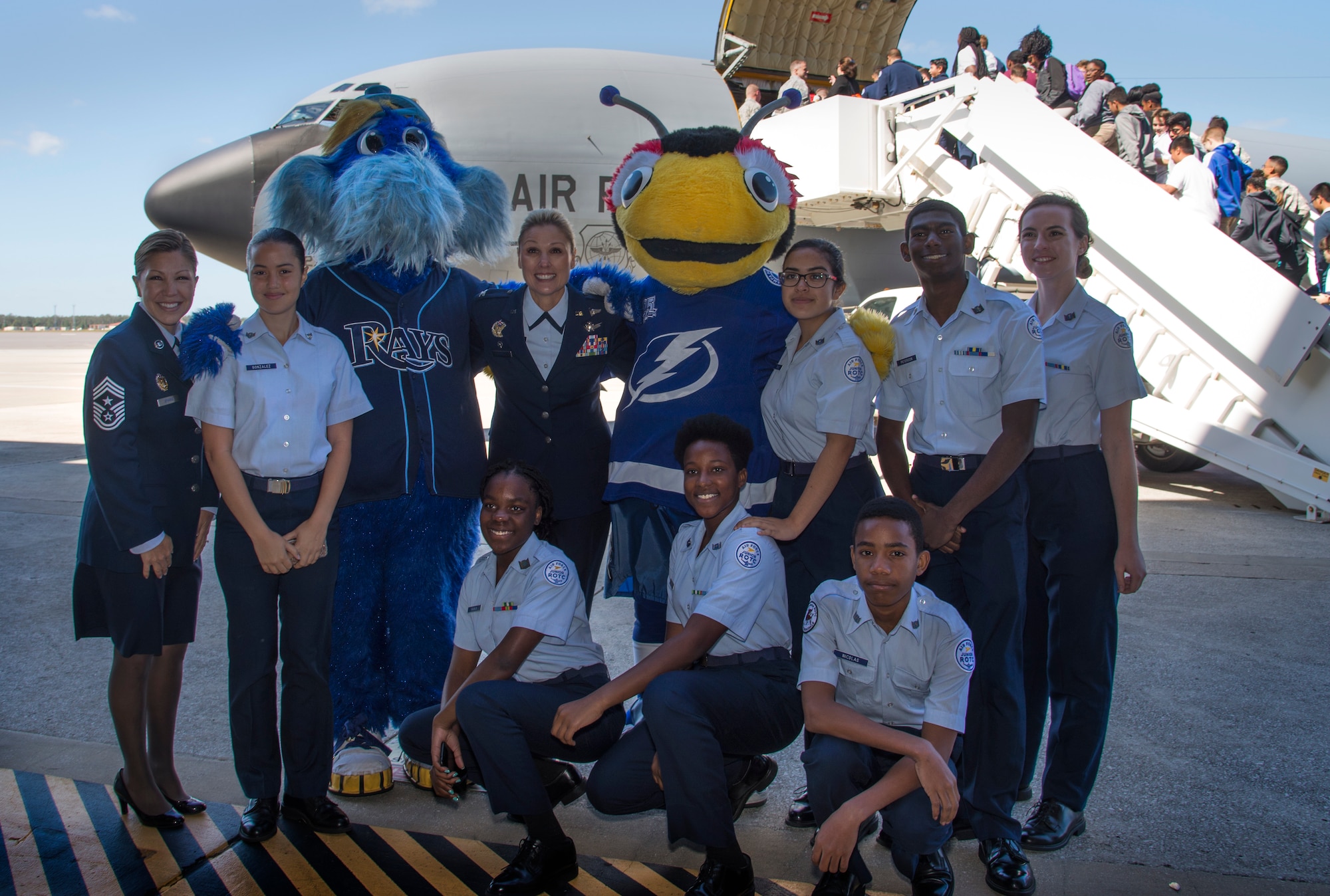 U.S. Air Force Col. April Vogel, the commander for the 6th Air Mobility Wing, pauses for a photo with students and Tampa Bay team mascots during the Science, Technology, Engineering, Arts and Math (STEAM) Day at MacDill Air Force Base, Fla., March 21, 2018.