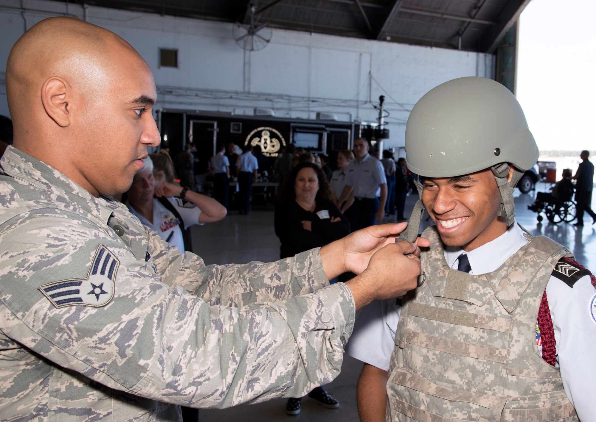 U.S. Air Force Senior Airman Christian Espada, an individual protective equipment journeyman assigned to the 6th Logistics Readiness Squadron, fits a student with an individual operator tactical vest (IOTV) and helmet during the Science, Technology, Engineering, Arts and Math (STEAM) Day at MacDill Air Force Base, Fla., March 21, 2018.