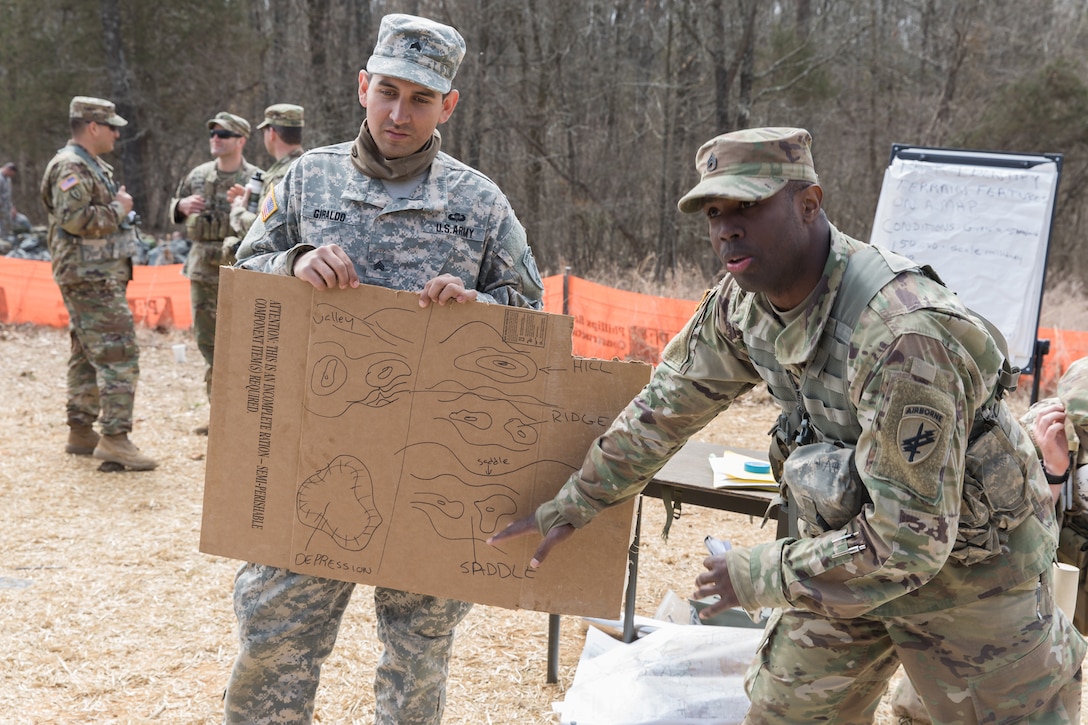 A soldier points at a map