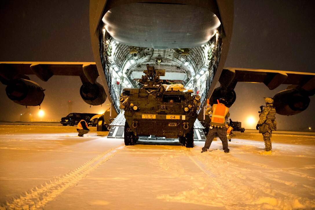 Airmen guide a vehicle onto an Air Force C-17 Globemaster.