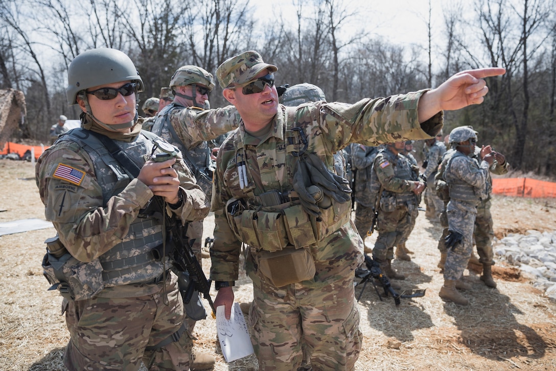 A soldier points out a target for another soldier during compass training.