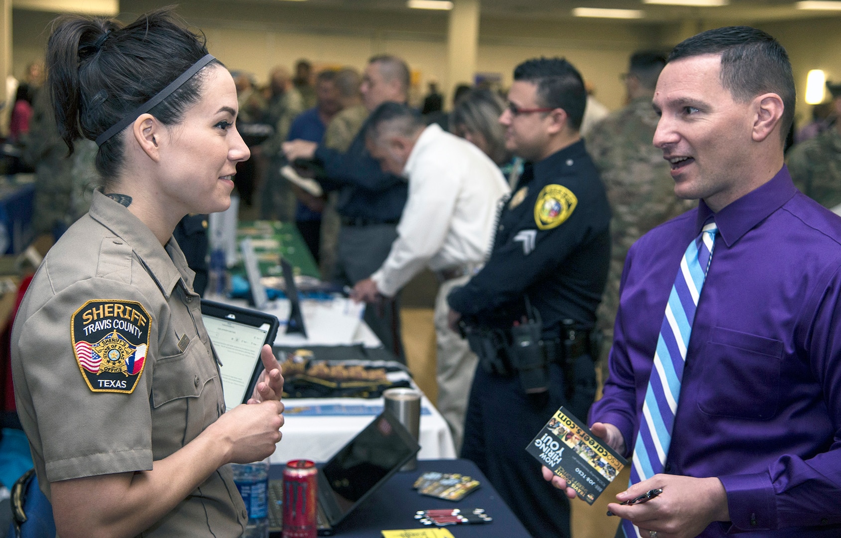 A recruiter with the Travis County Sheriff’s Office talks to a visitor at the Hiring Heroes Career Fair March 21 in the Sam Houston Community Center at Joint Base San Antonio-Fort Sam Houston. At the fair, transitioning, ill, injured and wounded service members, veterans and military spouses got to talk to representatives from employers, companies and governmental agencies on career opportunities.