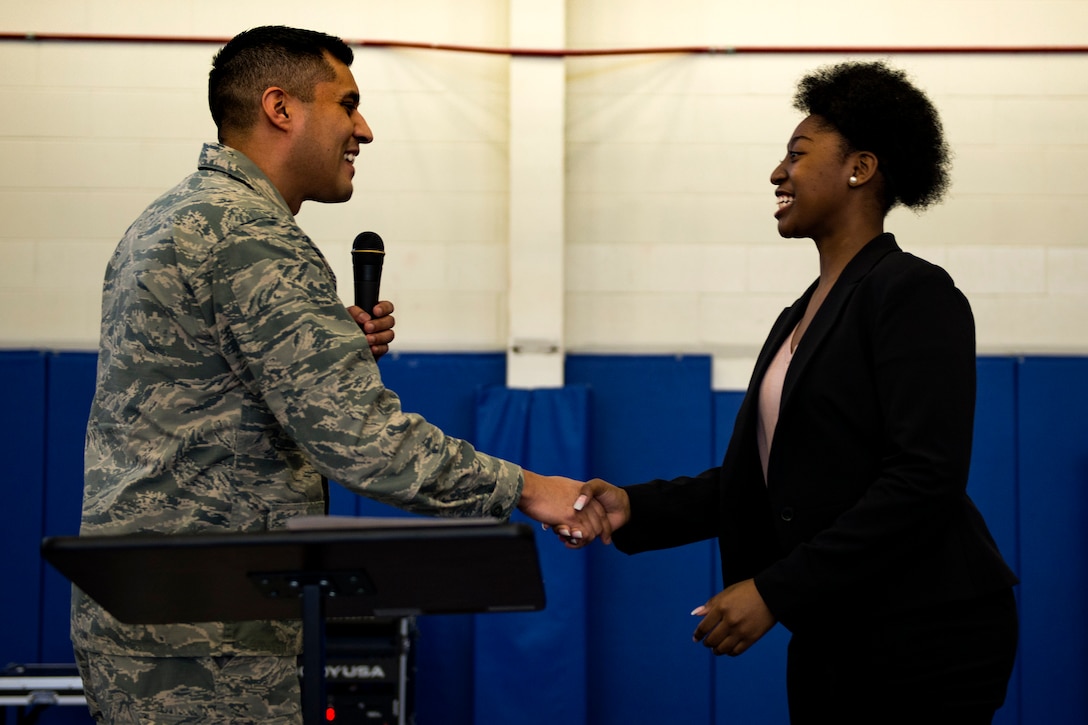 Lt. Col. Gregory Savella, left, 23d Force Support Squadron commander, coins Nevaeh Wallace, daughter of Master Sgt. Marvin Wallace, 723d Aircraft Maintenance Squadron first sergeant, and Master Sgt. Yolanda Wallace, 23d Wing chapel assistant, during the Youth of the Year Finalist Celebration, March 23, 2018, at Moody Air Force Base, Ga. The Youth Center hosted the event to give parents and community members a chance to see the competitors give their speeches they presented during the Georgia State Youth of the Year Competition. This was the first time two competitors from southeast region made it to the semifinals at the same time. (U.S. Air Force photo by Airman 1st Class Erick Requadt)
