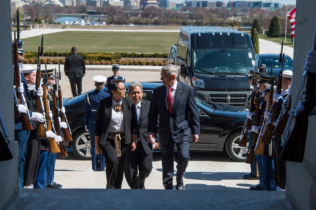 Defense Secretary James N. Mattis walks with the Indonesian foreign affairs minister up steps past an honor cordon at the Pentagon.