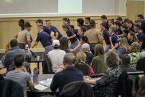Individuals who recently enlisted in the Marine Corps attempt to follow orders from drill instructors while their families look on during a Drill Instructor Family Night at Events Center West in West Des Moines, Iowa, March 23, 2018. Marine Corps Recruiting Command hosts the family nights to better prepare both parent and enlistee prior to attending Marine Corps Recruit Training. (Official U.S. Marine Corps photo by Sgt. Levi Schultz)