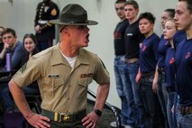 Sgt. Jordan Brown, drill instructor, 1st Recruit Training Regiment, yells commands to individuals who have recently enlisted in the Marine Corps during a Drill Instructor Family Night at Events Center West in West Des Moines, Iowa, March 23, 2018. Marine Corps Recruiting Command hosts the family nights to better prepare both parent and enlistee prior to attending Marine Corps Recruit Training. (Official U.S. Marine Corps photo by Sgt. Levi Schultz)