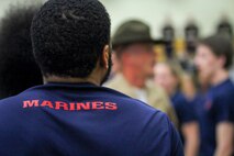 Individuals who recently enlisted in the Marine Corps attempt to follow orders from drill instructors during a Drill Instructor Family Night at Events Center West in West Des Moines, Iowa, March 23, 2018. Marine Corps Recruiting Command hosts the family nights to better prepare both parent and enlistee prior to attending Marine Corps Recruit Training. (Official U.S. Marine Corps photo by Sgt. Levi Schultz)