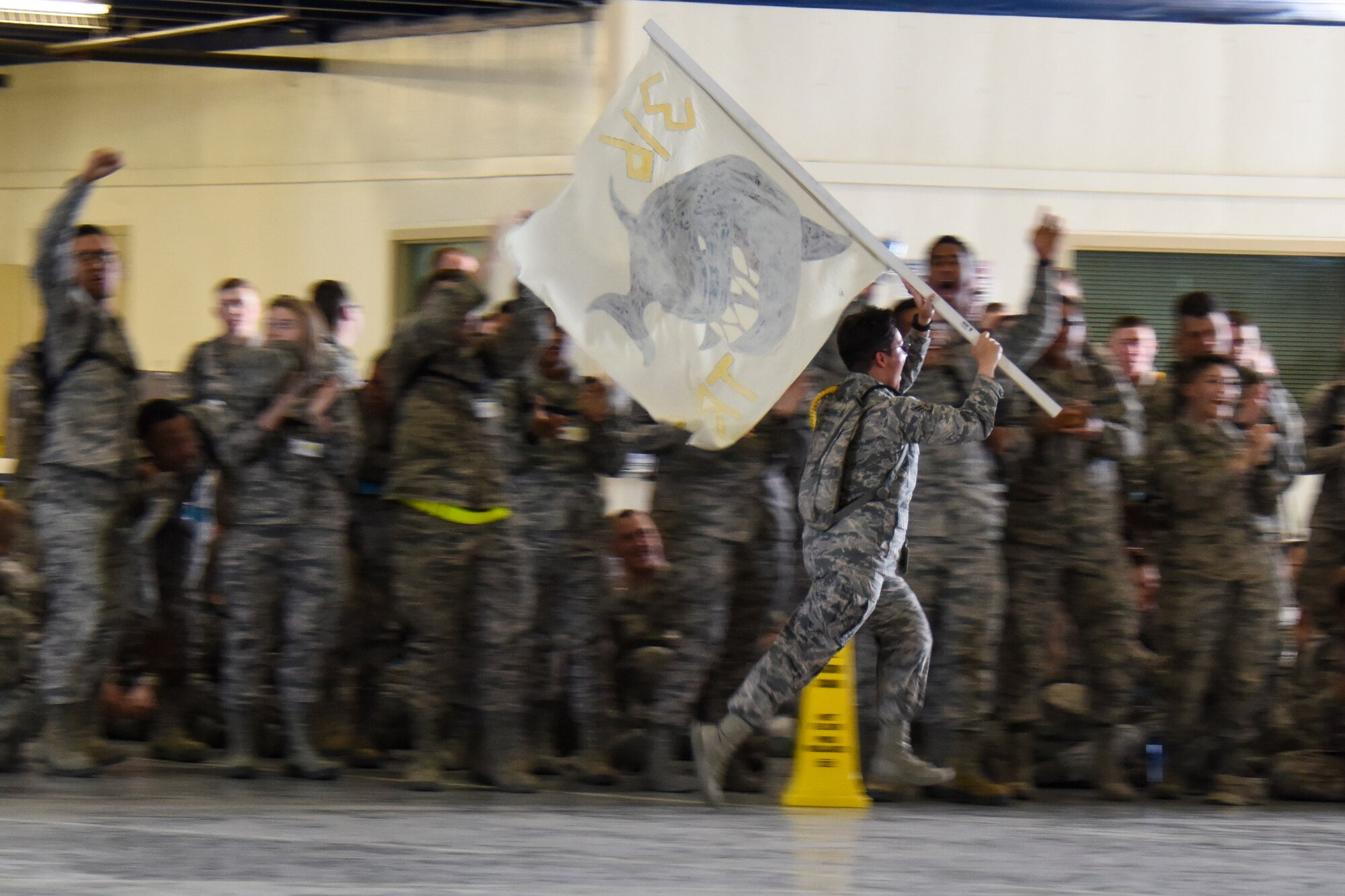 A trainee from the 316th Training Squadron races in front of the crowd pumping up the audience during the annual drill competition at the Louis F. Garland Department of Defense Fire Academy on Goodfellow Air Force Base, Texas, March 23, 2018. Each squadron had their mascots motivating the crowd and the competitors throughout the event. (U.S. Air Force photo by Airman 1st Class Zachary Chapman/Released)