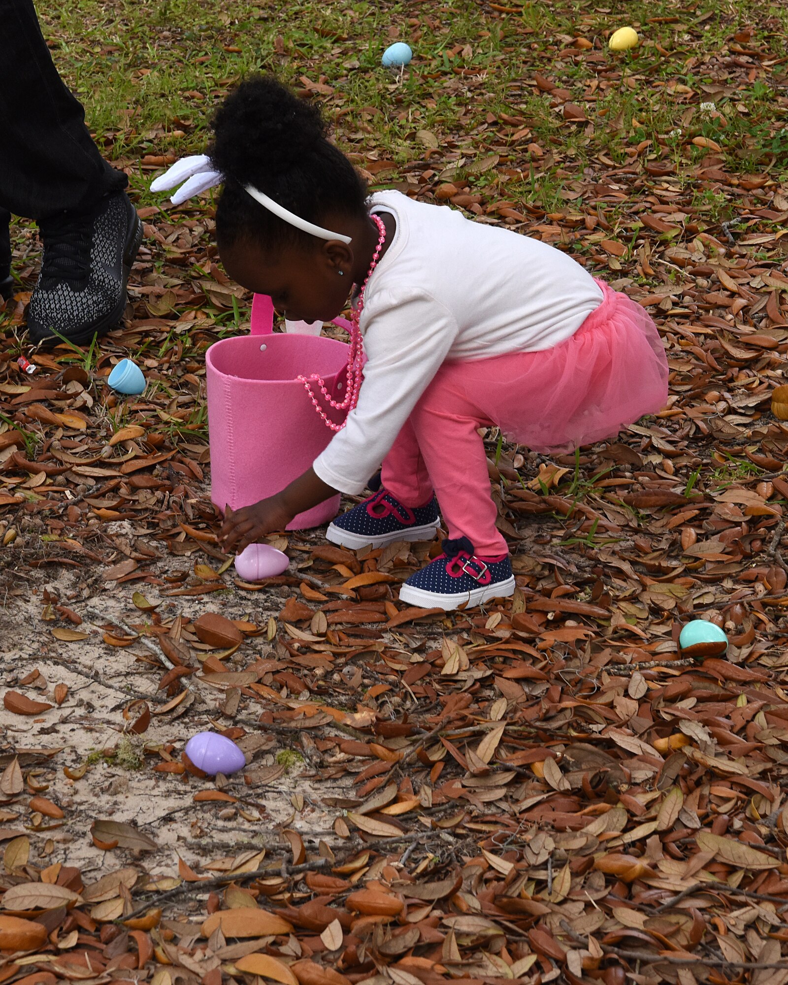 Tauryn Lennon, daughter of U.S. Air Force 2nd Lt. Taurean Lennon, 333rd Training Squadron Undergraduate Cyberspace Training student, picks up plastic eggs during Easter in the Park egg hunt at Marina Park March 24, 2018, on Keesler Air Force Base, Mississippi. The event festivities also included a parade, arts and crafts and informational booths. (U.S. Air Force photo by Airman 1st Class Suzie Plotnikov)