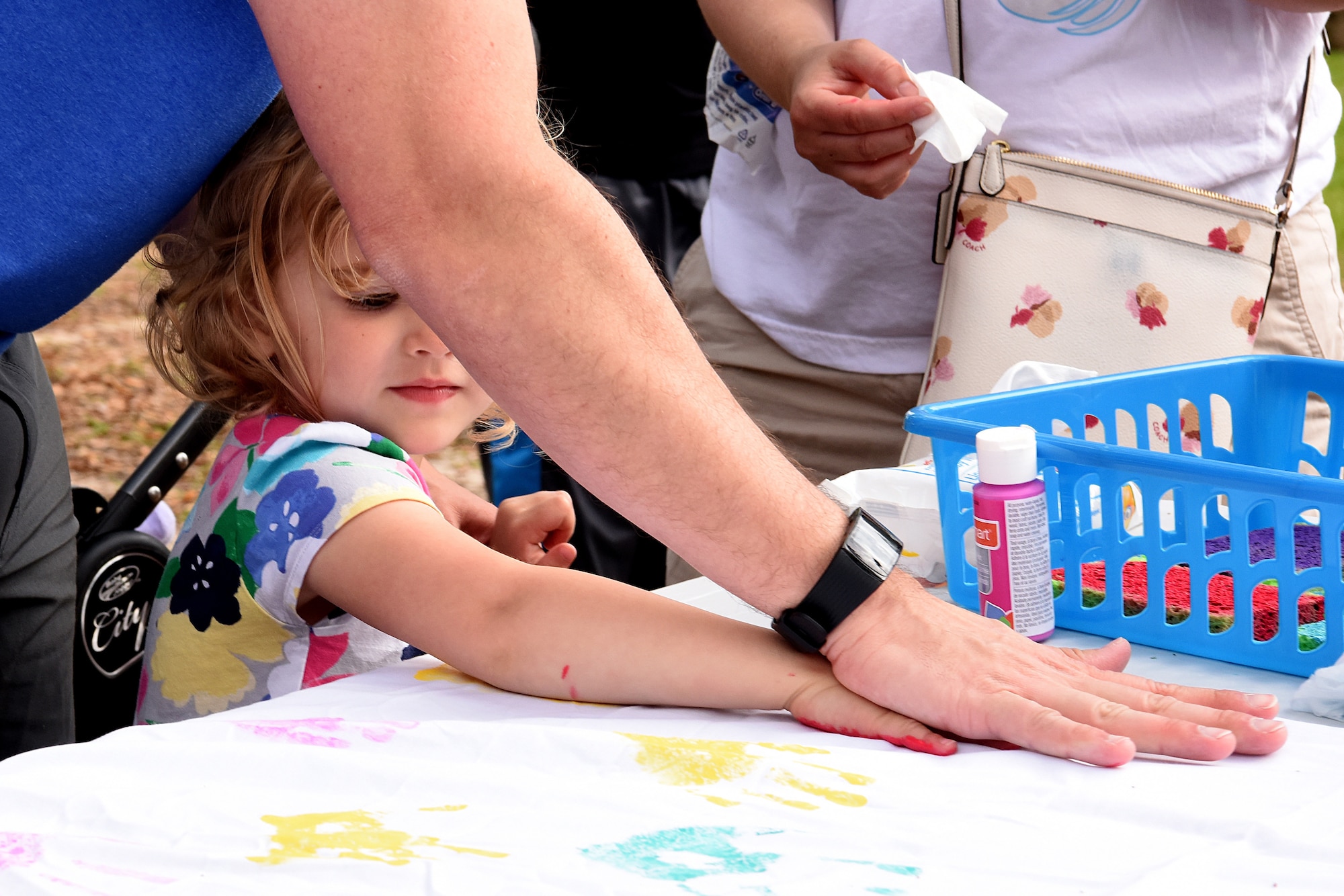 U.S. Air Force Lt. Col. John Eck, 2nd Air Force director of staff, and his daughter, Natalie, paints a handprint during Easter in the Park at Marina Park March 24, 2018, on Keesler Air Force Base, Mississippi. The event festivities included a parade, an Easter egg hunt, arts and crafts and informational booths. (U.S. Air Force photo by Airman 1st Class Suzie Plotnikov)