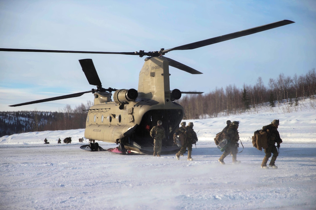 Marines disembark from a CH-47 Chinook helicopter.