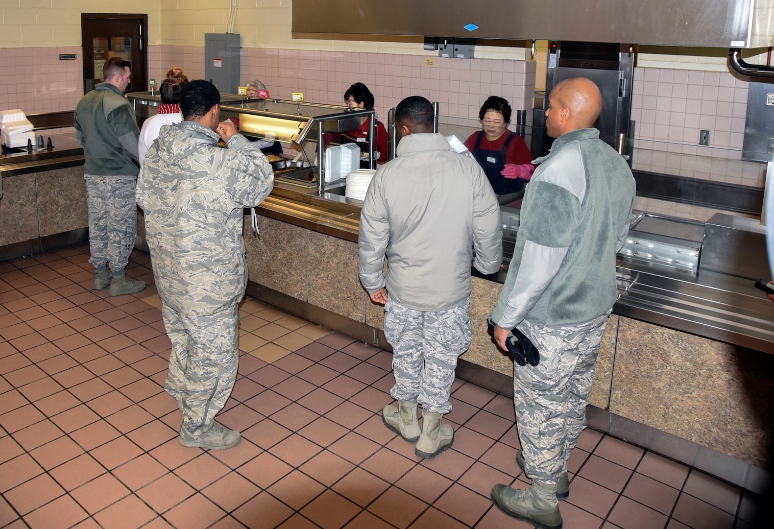 U.S. Air Force Airmen wait in line to get served during dinner, Jan. 24, 2018, at Kunsan Air Force Base, Republic of Korea. The dining facility staff are responsible of serving nearly 2,000 U.S. service members and any cash paying customer on a daily basis. (U.S. Air Force photo by Senior Airman Colby L. Hardin)