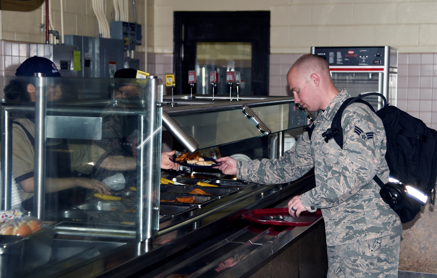 Contracted employees from the 8th Force Support Squadron, serve a service member during lunch, March 22, 2018 at Kunsan Air Base, Republic of Korea. The dining facility has more than 50 Korean Department of Defense and civilian employees staffed. (U.S. Air Force photo by Senior Airman Colby L. Hardin)