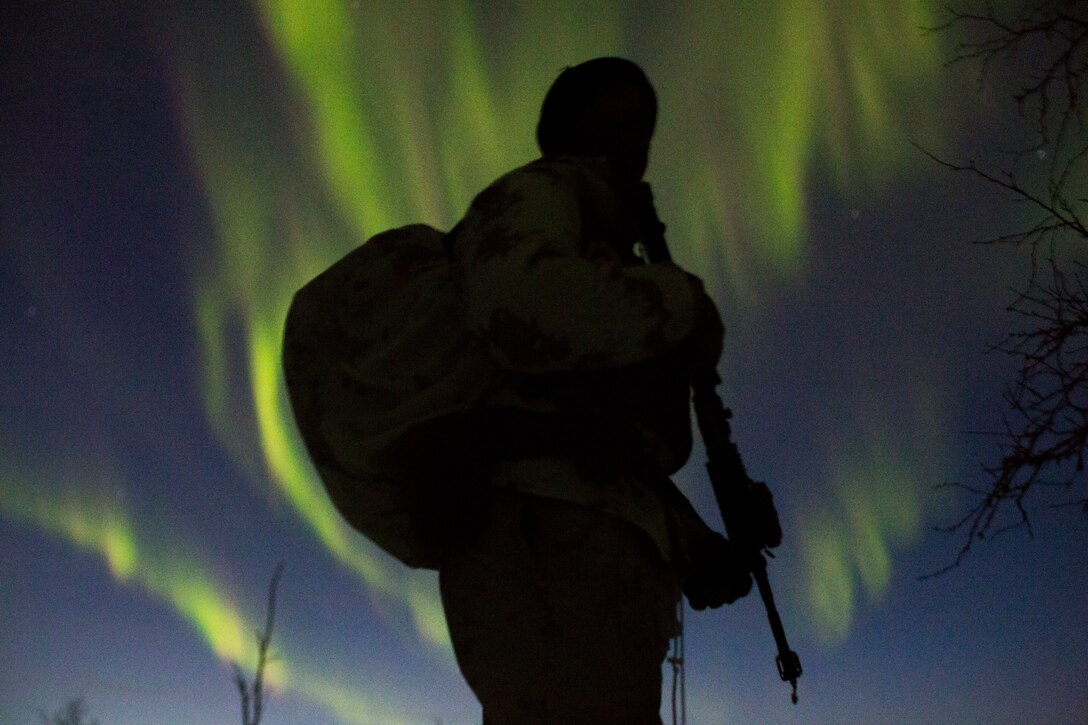 Marine with Marine Rotational Force-Europe prepares to conduct a mountainous assault on enemy position as the northern lights shine above during the field training exercise portion of Exercise White Claymore near Bardufoss, Norway, February 15, 2018. White Claymore is a U.K. Royal Marines-led training in northern Norway that focuses on winter warfare including training on movement in adverse terrain and over snow, and training in defensive and offensive operations in winter conditions. (U.S. Marine Corps photo by SSgt. Marcin Platek/Released)