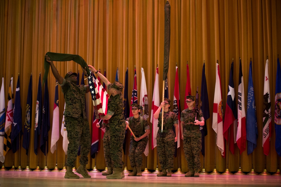 1st Sgt. Jamie L. Byrd, left, and Lt. Col. Matthew J. Kessler, uncover the U.S. flag during the III Marine Expeditionary Force Support Battalion activation ceremony, March 22, 2018 at Camp Hansen, Okinawa, Japan.