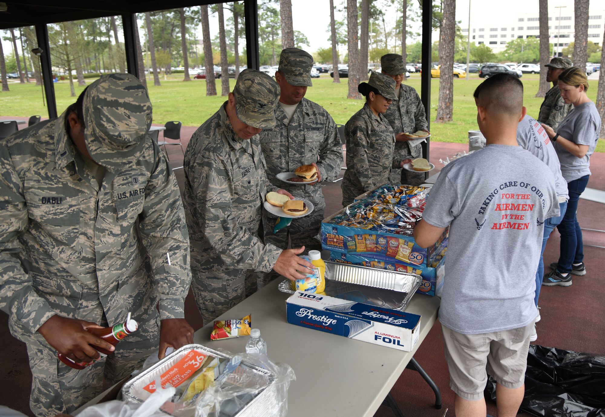 Keesler personnel get food during the Air Force Assistance Fund burger burn at the Crotwell Track March 26, 2018, on Keesler Air Force Base, Mississippi. The AFAF is an annual effort to raise funds for the charitable affiliates that provide support to our Air Force family in need. (U.S. Air Force photo by Kemberly Groue)