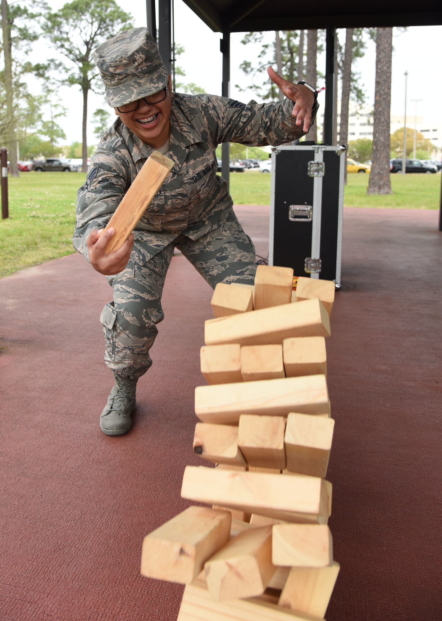U.S. Air Force Senior Airman Lucerno Salazar-Escamilla, 81st Surgical Operations Squadron physical medicine administration, participates in a game of Jenga during the Air Force Assistance Fund burger burn at the Crotwell Track March 26, 2018, on Keesler Air Force Base, Mississippi. The AFAF is an annual effort to raise funds for charitable affiliates that provide support to our Air Force family in need. (U.S. Air Force photo by Kemberly Groue)