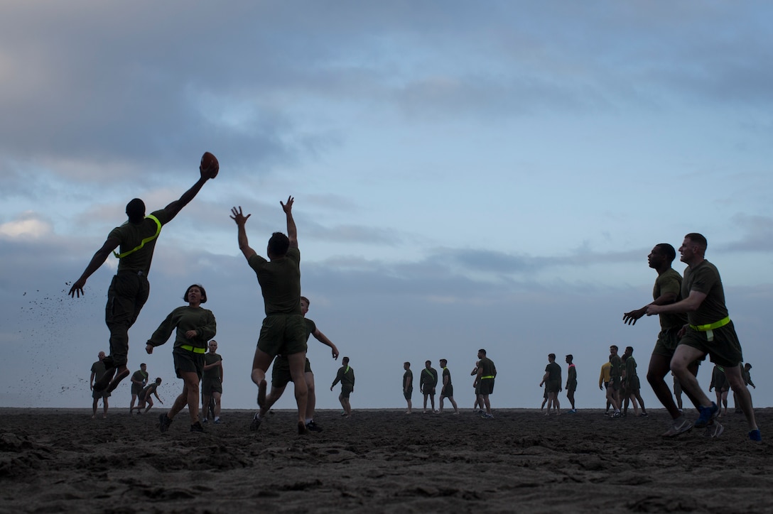 U.S. Marine Sgt. Marcus Mack, a native of Landover, Maryland and administrative specialist assigned to the 15th Marine Expeditionary Unit, catches a football during a game of ultimate football as part of the unit’s resiliency training program, March 23, 2018. The program is designed to foster camaraderie and unit cohesion, where each member participates in a scenario-based guided discussion at the conclusion of the physical training session.