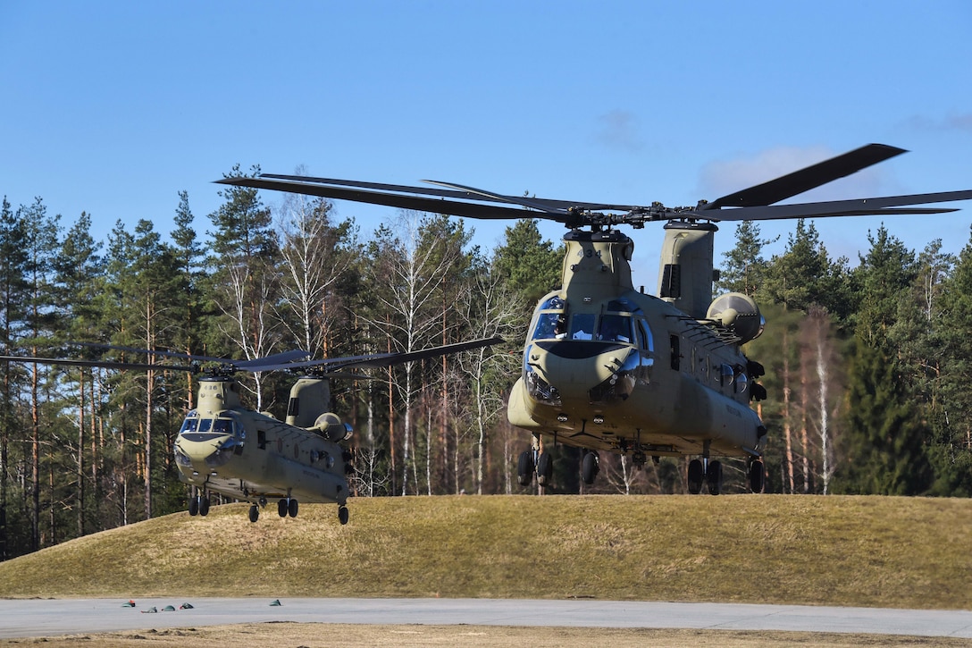 Helicopters lift off transporting soldiers.