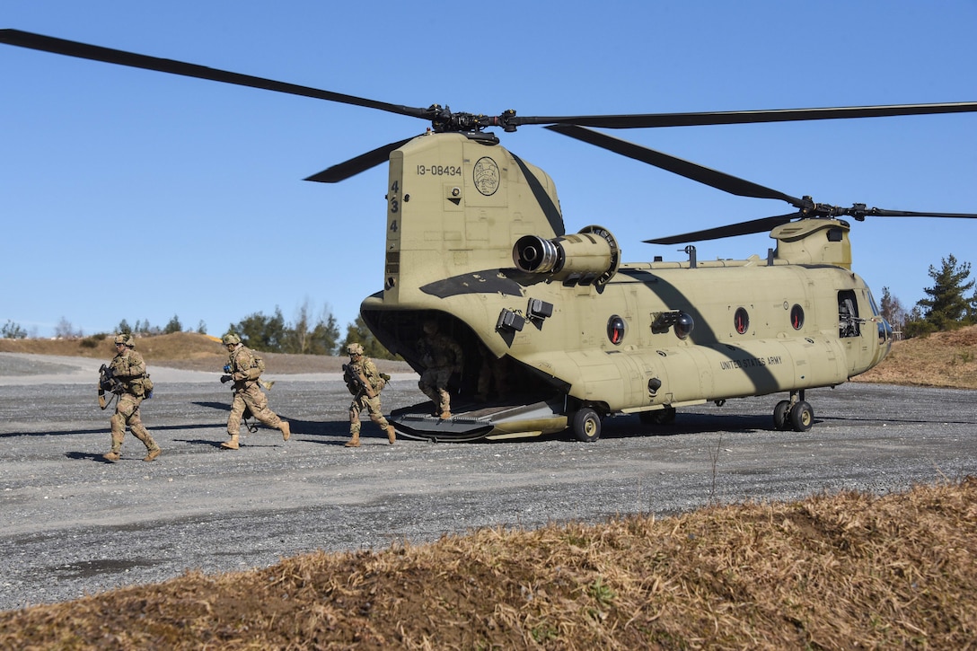 Soldiers disembark a CH-47 Chinook helicopter.