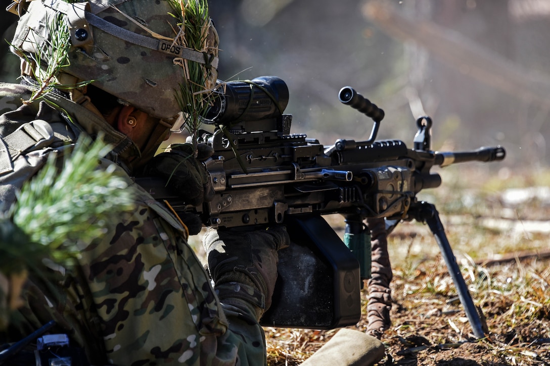 A soldier fires a M249 light machine gun.