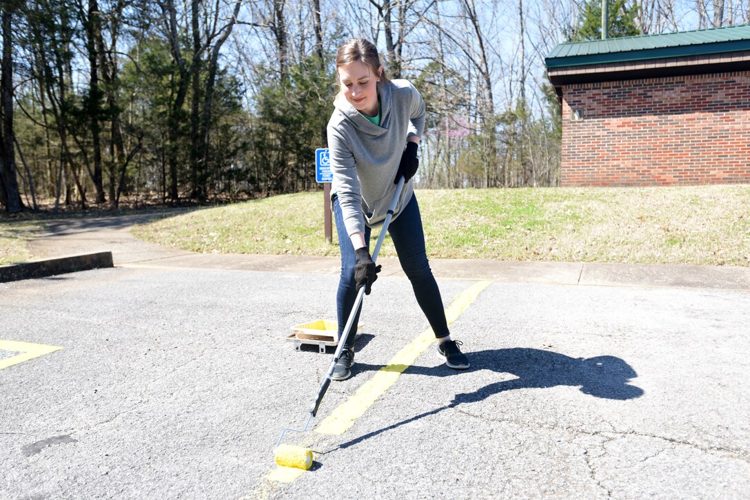 Summer Dowdy, strategic planner with VF Solutions, paints parking spot stripes while volunteering for an early Earth Day clean-up event March 22, 2018 at Seven Points Campground on the shoreline of J. Percy Priest Lake in Hermitage, Tenn. Sixty VF Solutions employees partnered with the U.S. Army Corps of Engineers Nashville District to spruce up the popular campground ahead of the 2018 recreation season. (USACE photo by Lee Roberts)
