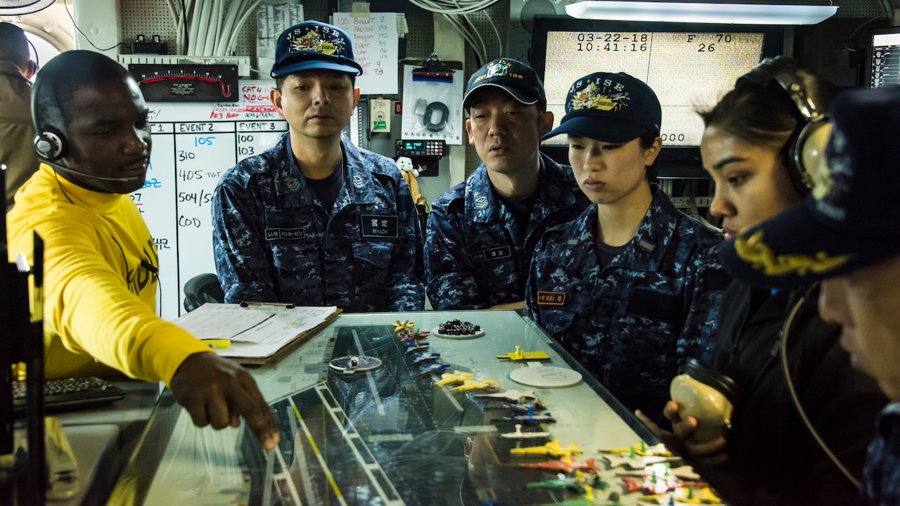 U.S. and Japanese sailors tour Japanese naval vessel.