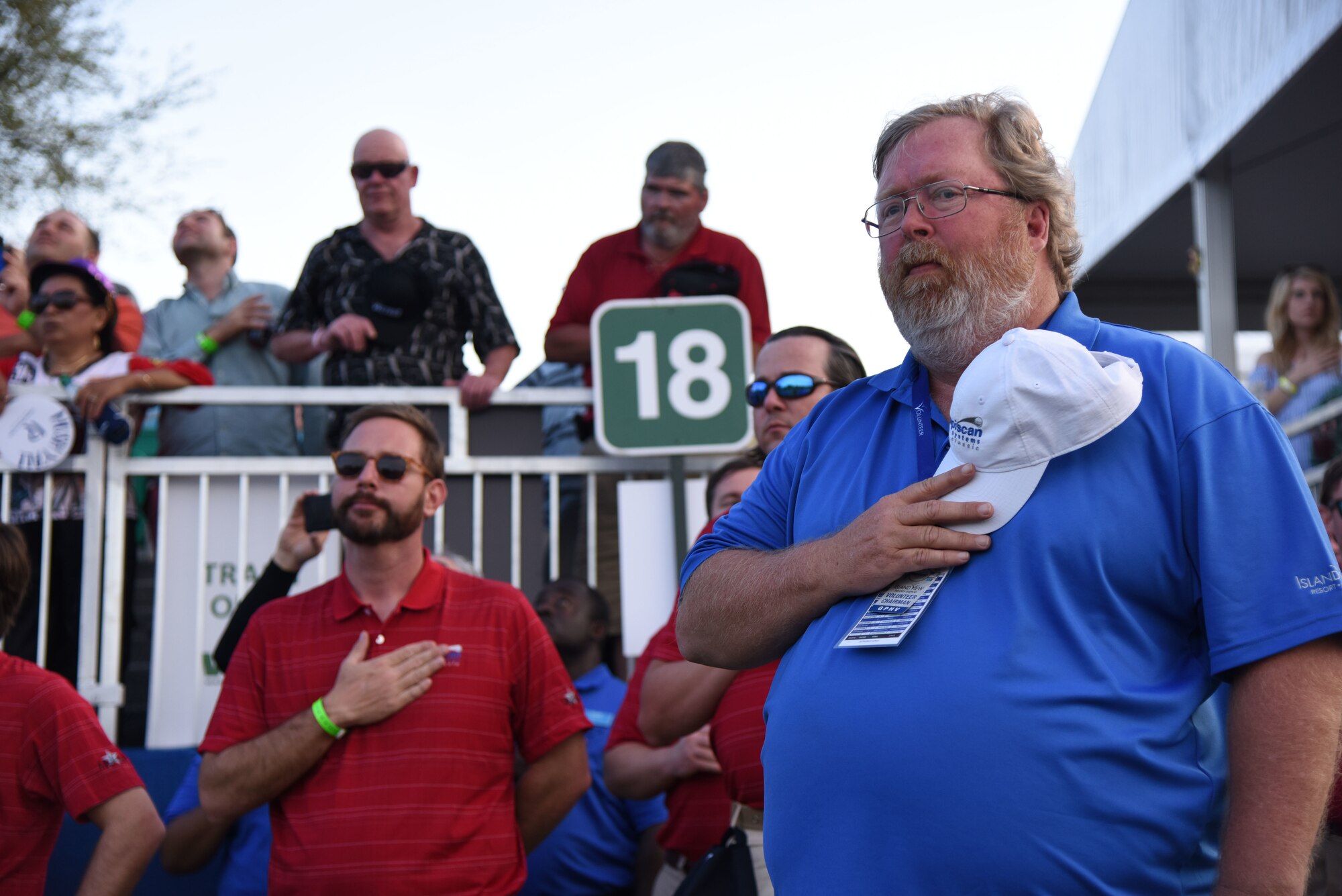 Sam Foster, 81st Training Wing information protection chief, places his hand over his heart during the singing of the national anthem during the Rapiscan Systems Classic Champions Tour at Fallen Oak Golf Club March 25, 2018, in Saucier, Mississippi. Keesler personnel performed the national anthem and presented the colors during the closing ceremony of the three-day event. This is the fifth year that the event has been held on the coast. (U.S. Air Force photo by Kemberly Groue)