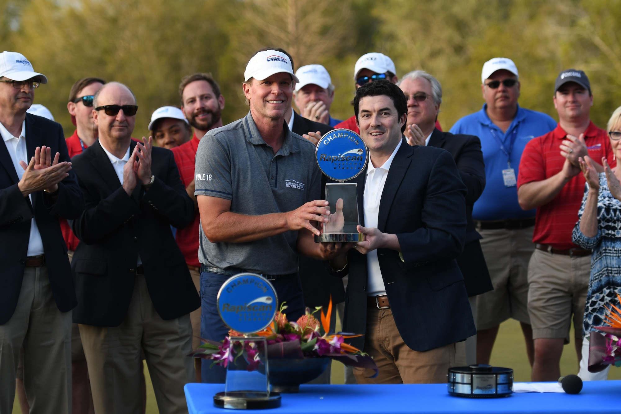 Jonathan Jones, Rapiscan Systems Classic president, presents the trophy to Steve Stricker, Professional Golfers’ Association golfer, after winning the Rapiscan Systems Classic Champions Tour at Fallen Oak Golf Club March 25, 2018, in Saucier, Mississippi. Keesler personnel performed the national anthem and presented the colors during the closing ceremony of the three-day event. (U.S. Air Force photo by Kemberly Groue)
