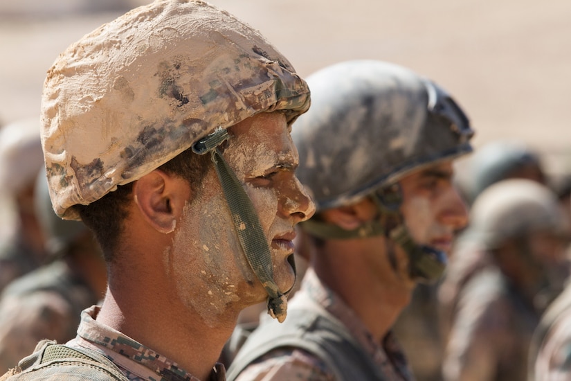 A Jordanian service member stands in formation during graduation of the Jordan Armed Forces Noncommissioned Officer Academy Squad Leader Course, March 22, 2018, near Amman, Jordan. The graduating class was covered in mud to practice camouflage technique and also as a rite of passage. U.S. advisors assisted in the development of the Jordanian-led course.