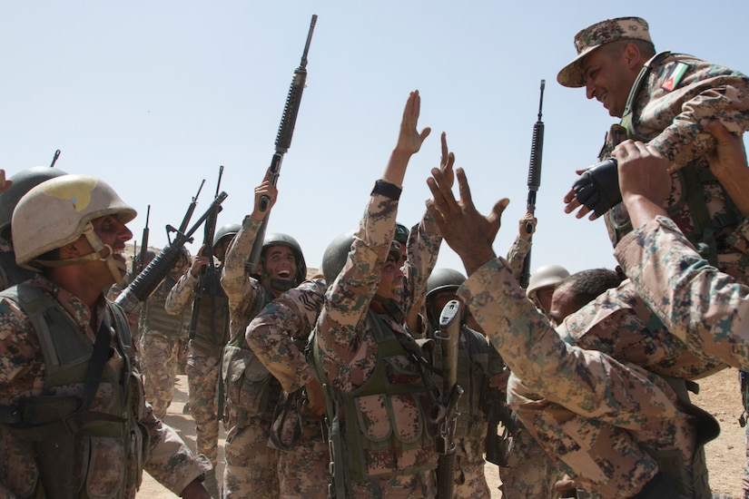 Jordanian service members lift Command Sgt. Maj. Mohammad Al-Smadi, commandant, Jordan Armed Forces Noncommissioned Officer Academy, and sing in celebration at the conclusion of the culminating exercise of the JAF NCOA Squad Leader Course, March 21, 2018, near Amman, Jordan. U.S. advisors assisted in the development of the Jordanian-led course.
