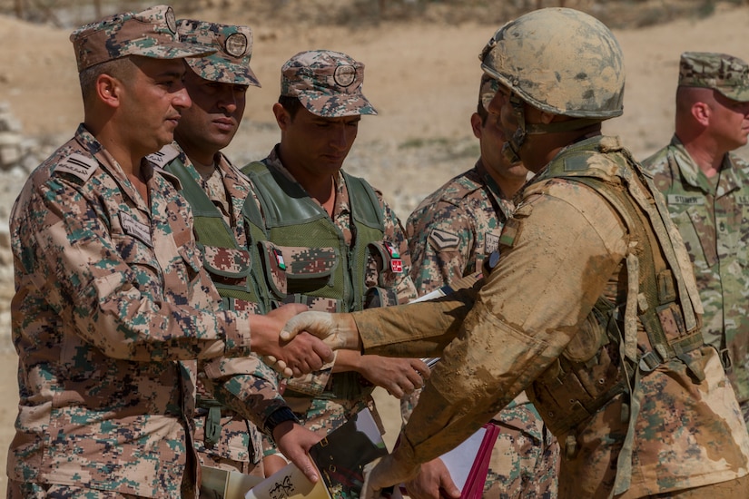 A Jordanian service member receives his diploma from Command Sgt. Maj. Mohammad Al-Smadi, commandant, Jordan Armed Forces Noncommissioned Officer Academy, during the graduation for the JAF NCOA Squad Leader Course, March 22, 2018, near Amman, Jordan. U.S. advisors assisted in the development of the Jordanian-led course.