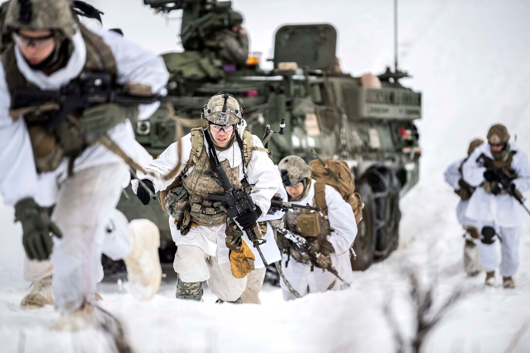 Soldiers patrol a snowy hillside.