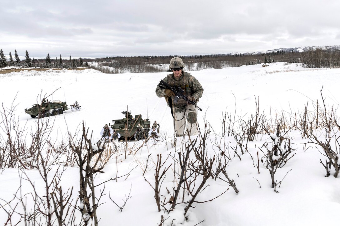 Soldiers patrol through the snow.